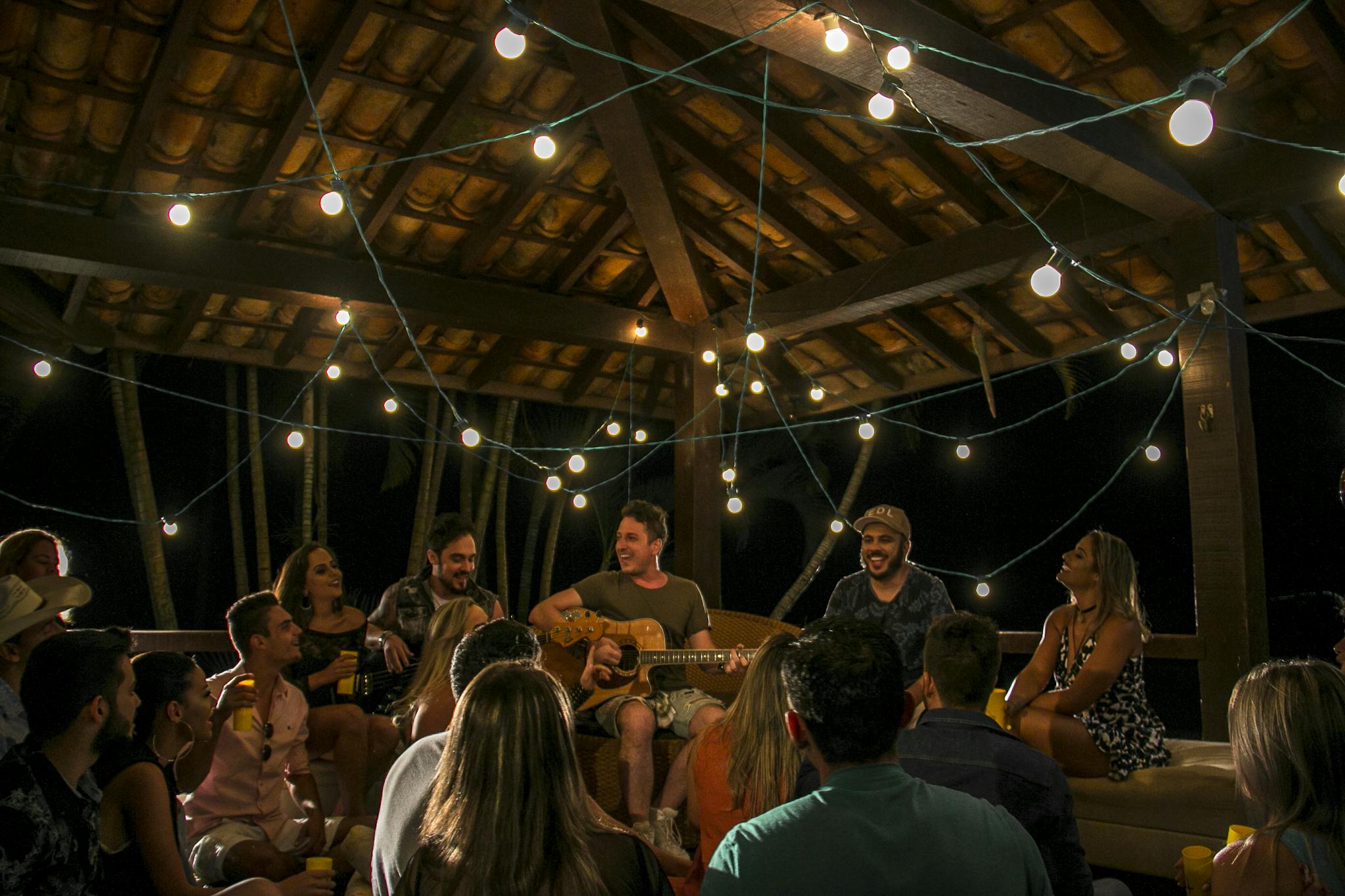 An intimate musical gathering under string lights in São Paulo, Brazil.