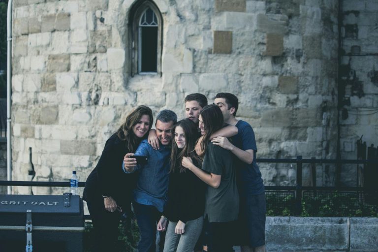 Group of friends enjoying a moment together while taking a selfie outdoors.