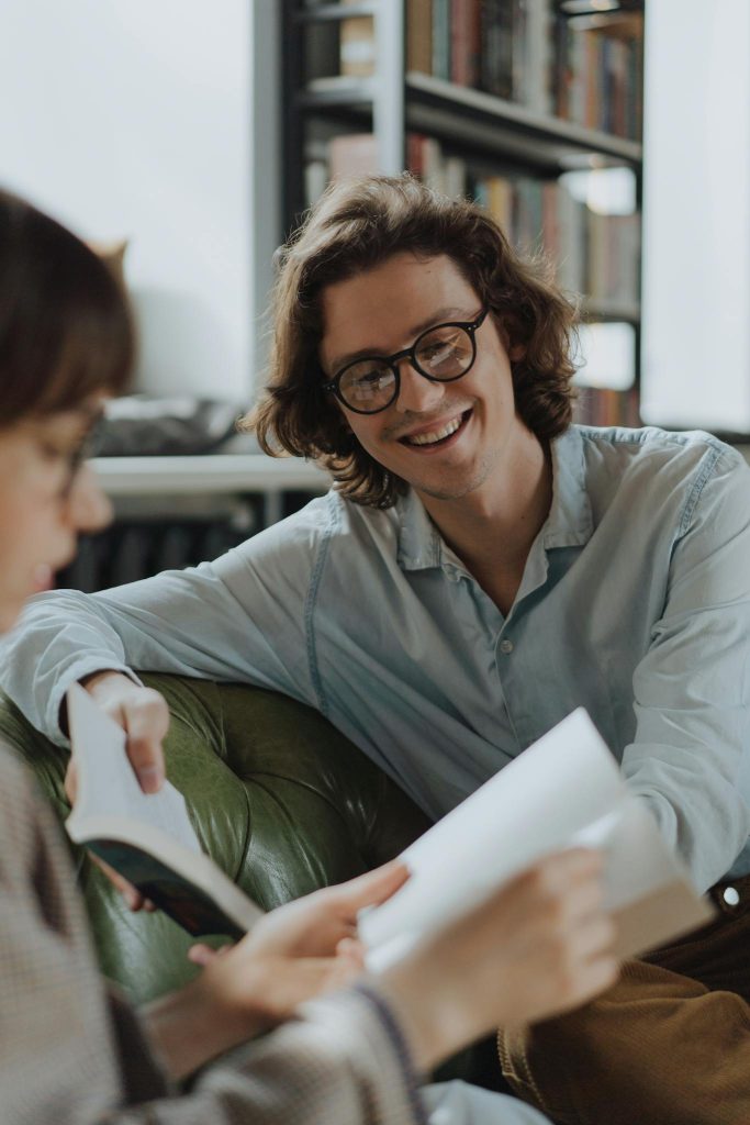 Two people in conversation, reviewing written materials together in a calm, collaborative setting.